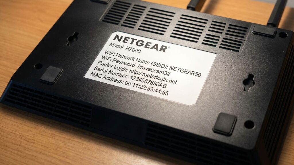 Netgear router bottom sticker showing routerlogin.net default login details and WiFi password